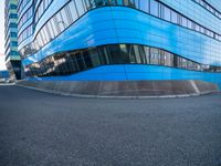 a man holding a frisbee standing on a road near a building that looks very futuristic