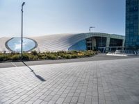 a picture of a building by some large buildings with a large circle at the top