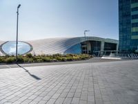 a picture of a building by some large buildings with a large circle at the top