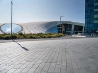 a picture of a building by some large buildings with a large circle at the top