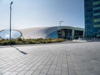 a picture of a building by some large buildings with a large circle at the top