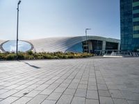 a picture of a building by some large buildings with a large circle at the top