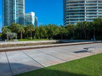 an empty area in front of a large residential building, surrounded by palm trees and greenery