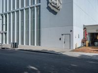 a white building with some windows on the side and a lion head statue on the outside