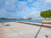 the view of a harbor area next to a dock with a bench, and the sky