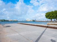 the view of a harbor area next to a dock with a bench, and the sky