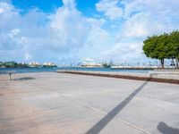 the view of a harbor area next to a dock with a bench, and the sky