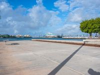 the view of a harbor area next to a dock with a bench, and the sky