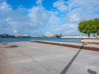 the view of a harbor area next to a dock with a bench, and the sky