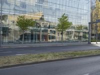 a car parked at an intersection and an empty street with buildings in the background glass, surrounded by green grass