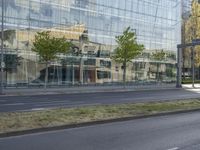 a car parked at an intersection and an empty street with buildings in the background glass, surrounded by green grass