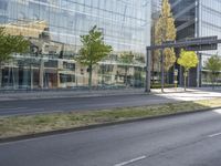 a car parked at an intersection and an empty street with buildings in the background glass, surrounded by green grass