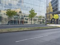 a car parked at an intersection and an empty street with buildings in the background glass, surrounded by green grass