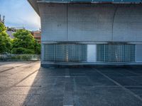 two empty parking spaces with two empty doors and a large window on the wall between two buildings