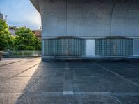 two empty parking spaces with two empty doors and a large window on the wall between two buildings