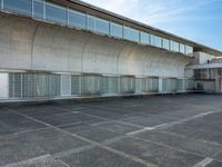 two empty parking spaces with two empty doors and a large window on the wall between two buildings