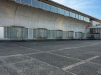 two empty parking spaces with two empty doors and a large window on the wall between two buildings