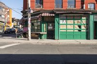 the side street corner with a bench in front of a building and a few cars parked at the intersection