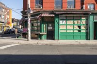 the side street corner with a bench in front of a building and a few cars parked at the intersection