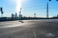 two red stop lights on the corner of a road with a bridge in the distance