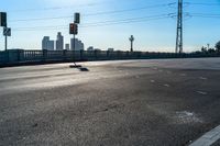 two red stop lights on the corner of a road with a bridge in the distance