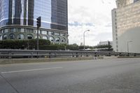 empty highway with a traffic light in between two buildings on the other side of the road