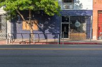 an empty city street with a sign that reads green on the sidewalk in front of a store