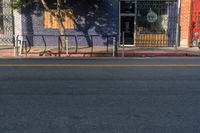 an empty city street with a sign that reads green on the sidewalk in front of a store