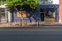 an empty city street with a sign that reads green on the sidewalk in front of a store