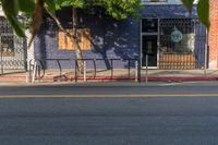 an empty city street with a sign that reads green on the sidewalk in front of a store