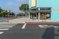 a car driving down the street with a sunbeam store in the background at an intersection