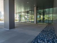 two grey blocks sitting next to a tall building on a sidewalk in front of grass