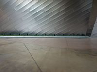 a person sitting on a skate board in front of a building with lines that form a wall