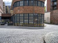 a brick building is pictured in this photograph of a courtyard in the city of manchester