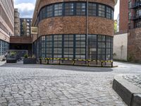 a brick building is pictured in this photograph of a courtyard in the city of manchester