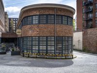 a brick building is pictured in this photograph of a courtyard in the city of manchester