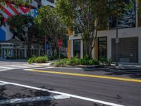 empty street in front of an urban building with trees and a stop sign on a corner