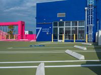 an outside shot of a sports court with ramps on either side of it and a building behind it