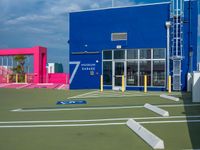 an outside shot of a sports court with ramps on either side of it and a building behind it