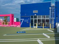 an outside shot of a sports court with ramps on either side of it and a building behind it