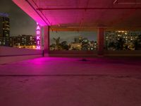 the roof terraced area features a brightly lit sign and graffiti on the concrete, while pink is in the dark