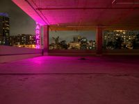 the roof terraced area features a brightly lit sign and graffiti on the concrete, while pink is in the dark