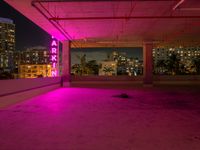 the roof terraced area features a brightly lit sign and graffiti on the concrete, while pink is in the dark