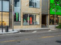 the back of a car drives down a street past a storefront window with clothing displayed in the glass