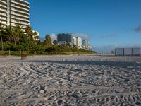 a large white building sitting on the top of a beach next to buildings and trees