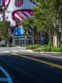 the street has cars driving on it and an office building in the background with flags in the shape of a dog