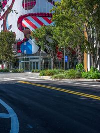 the street has cars driving on it and an office building in the background with flags in the shape of a dog