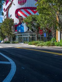 the street has cars driving on it and an office building in the background with flags in the shape of a dog