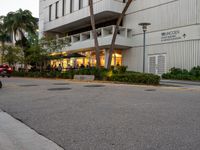 a street view of an asian american hotel or apartment building, and people sitting on the sidewalk