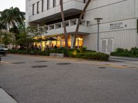 a street view of an asian american hotel or apartment building, and people sitting on the sidewalk